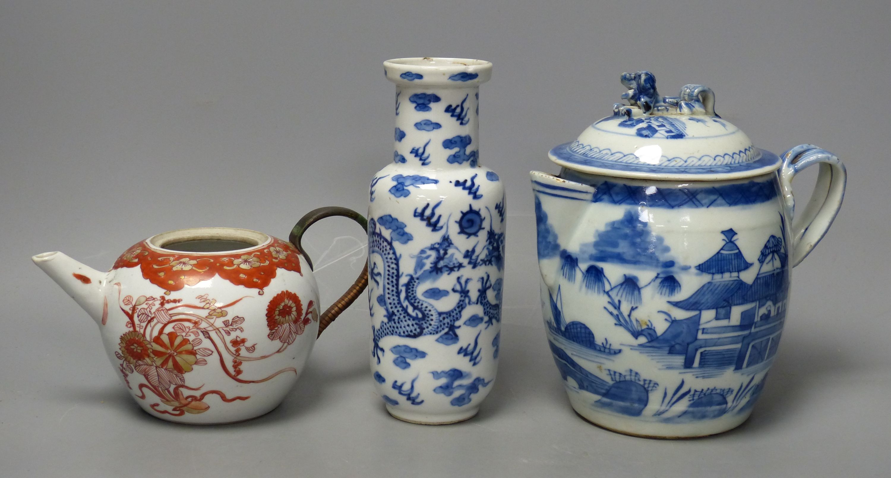 A 19th century Chinese blue and white covered jug, an early 20th century blue and white vase and a Kangxi rouge de fer teapot, tallest 18cm